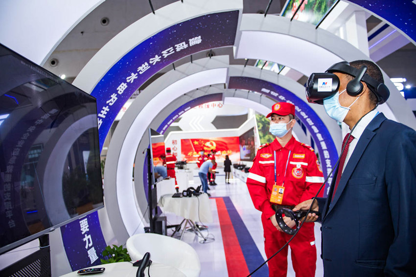 5月21日，重慶國際博覽中心N3館中國安能集團(tuán)展廳，外籍客商戴上VR眼鏡、操作手柄，體驗(yàn)防汛險(xiǎn)情、校園地震逃生等虛擬現(xiàn)實(shí)場(chǎng)景，學(xué)習(xí)避險(xiǎn)知識(shí)。鄒樂攝