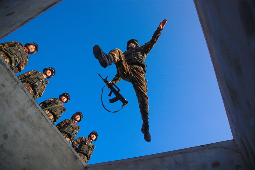 武警官兵進(jìn)行攜槍跨越壕溝訓(xùn)練。彭勇攝