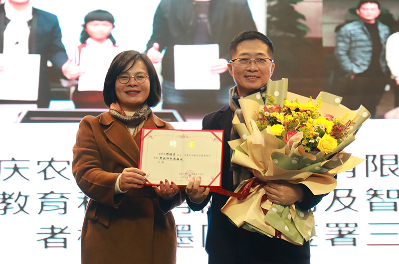 魏莉為鄧鴻吉頒發(fā)學(xué)校聘書。黃炎培中學(xué)供圖