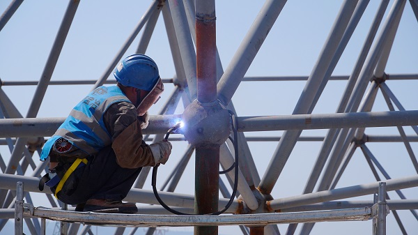 工人正在進(jìn)行鋼架結(jié)構(gòu)施工。唐鑫攝