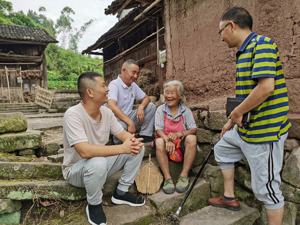 駐村工作隊(duì)和村干部入戶走訪。胡俐俠攝