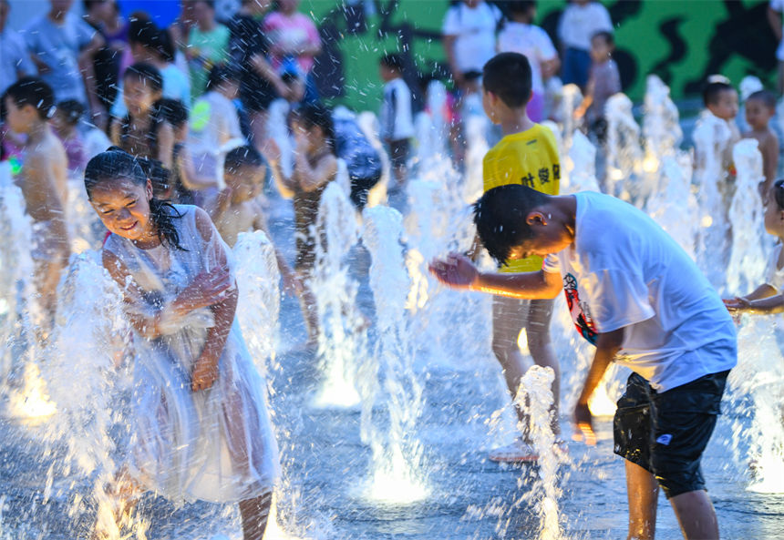重慶連晴高溫，小朋友在南濱路噴泉下戲水玩耍享受清涼。郭旭攝