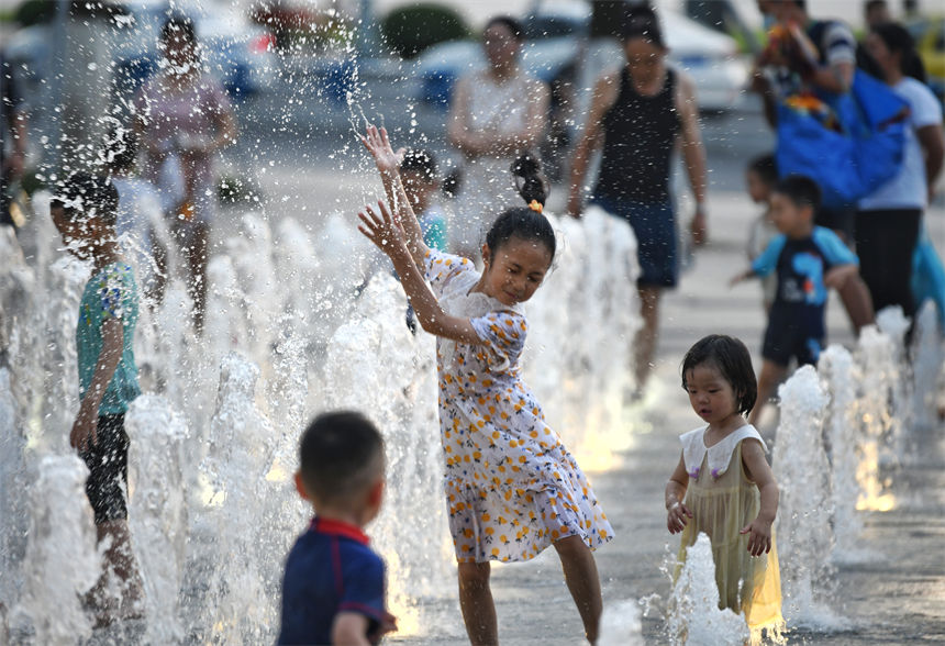 重慶連晴高溫，小朋友在南濱路噴泉下戲水玩耍享受清涼。郭旭攝
