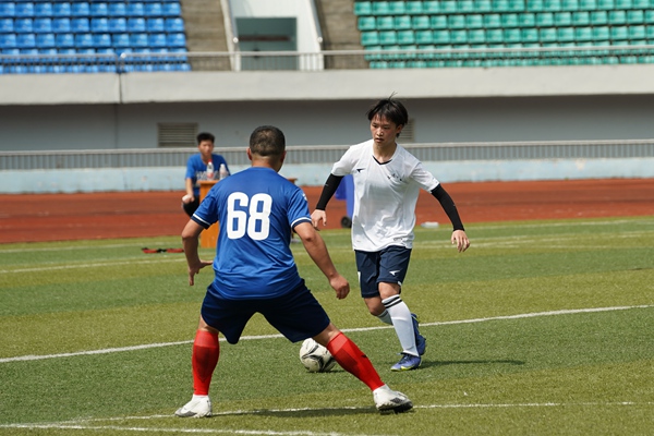 馬慶林（白衣者）帶球突破。石柱縣委宣傳部供圖