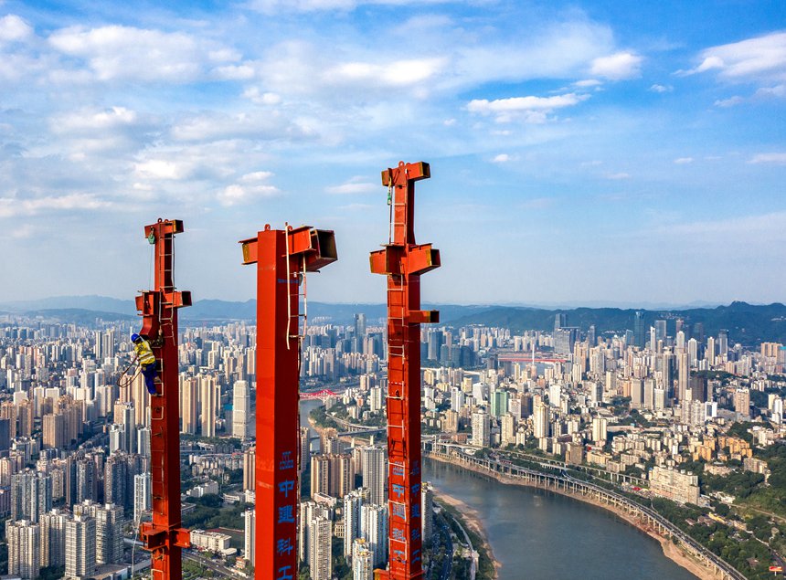 重慶陸海國際中心項目工人在熾熱的鋼結(jié)構(gòu)上做施工前準備。何超攝