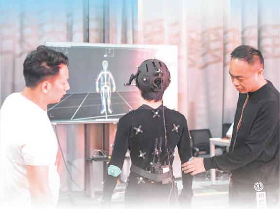 盧琪（右）在影像科技虛擬攝影棚與工作人員交流。王全超攝（人民視覺）