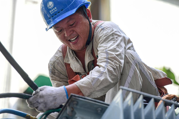 7月13日，國(guó)網(wǎng)合川供電公司員工在10千伏皂蟠線公園路中人2號(hào)臺(tái)區(qū)搶險(xiǎn)配變。秦曉東攝