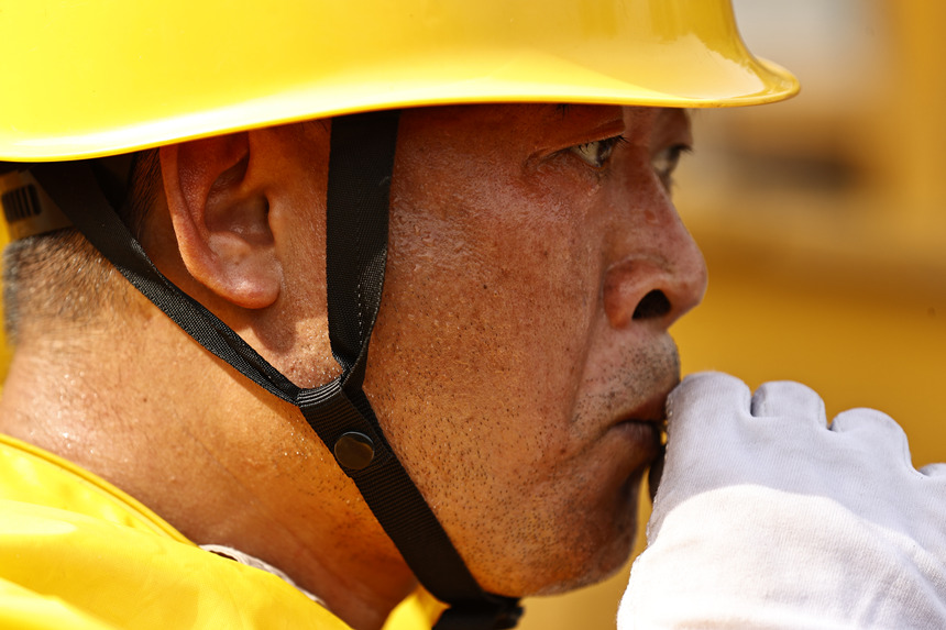 作業(yè)結(jié)束后，工作人員喝下藿香正氣液進行消暑。國網(wǎng)重慶市電力公司供圖