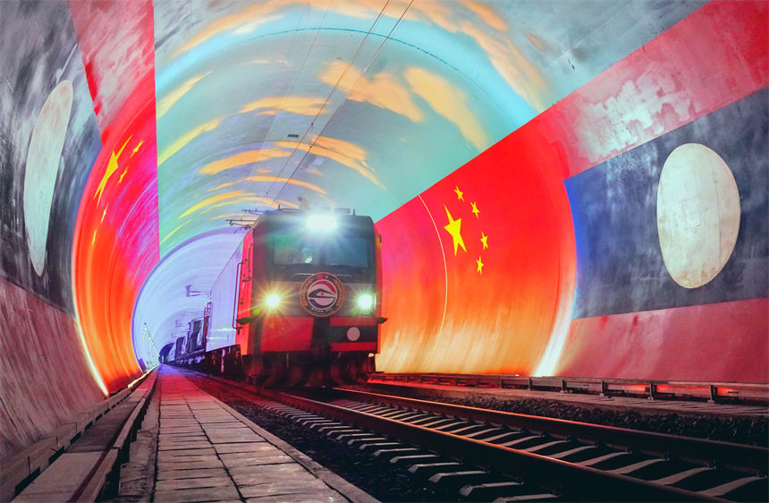 在中國和老撾兩國國旗映襯下,衛(wèi)生列車即將在中老鐵路“友誼隧道”內(nèi)跨越中老兩國邊境。凱喬攝