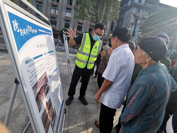 《“地災(zāi)科普進(jìn)萬家 防災(zāi)減災(zāi)靠大家”科普宣傳》。6月14日，在巴南區(qū)東溫泉鎮(zhèn)河邊廣場(chǎng)，重慶一三六地質(zhì)隊(duì)隊(duì)員杜健正向過往群眾講解地災(zāi)科普知識(shí)。楊靖攝