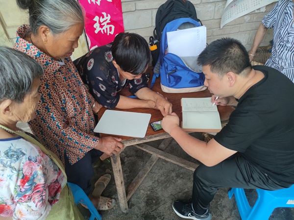 《駐守隊員向老百姓宣傳地災(zāi)知識》。6月23日，南江地質(zhì)隊駐守隊員向鋒在雨中巡查時向黃柏鄉(xiāng)三坪村老百姓宣傳地災(zāi)知識。劉偉攝