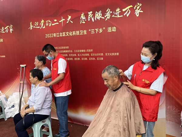 青年志愿者為老人公益剪發(fā)、按摩。蔣海濤攝