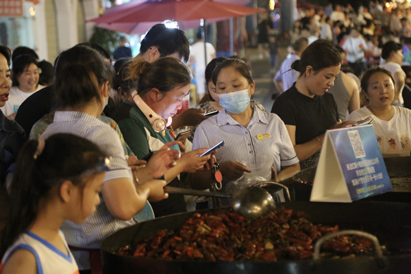 游客品嘗海鮮燒烤。楊孝永攝