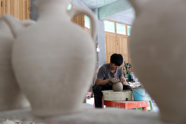 羅達(dá)川在給陶坯造型。黔江區(qū)委宣傳部供圖