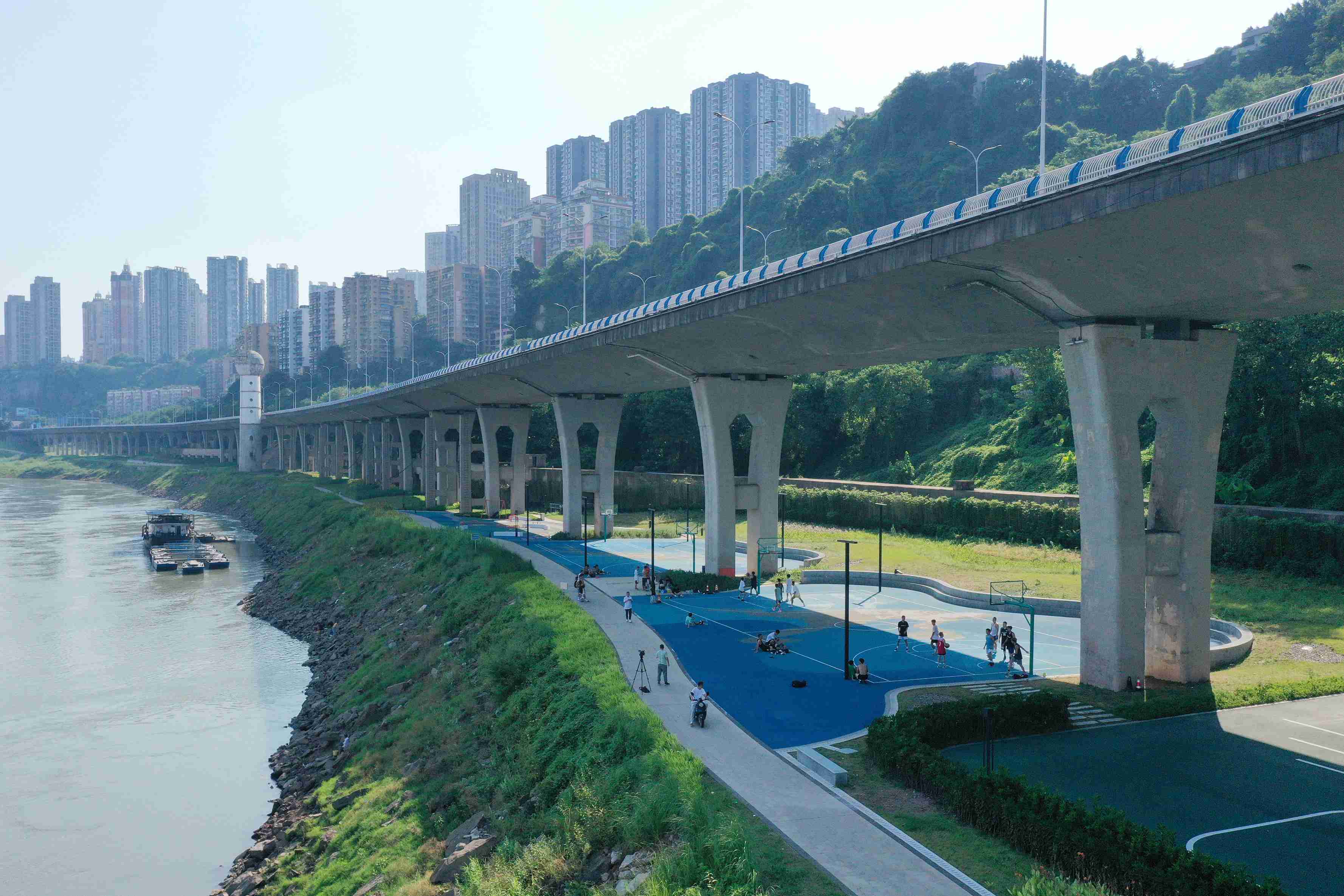 在渝中區(qū)黃沙溪大橋下，市民在長江邊的籃球場打球。何超攝