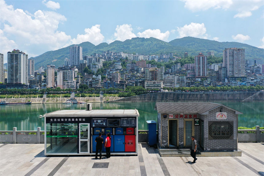 在彭水苗族土家族自治縣南濱路生活垃圾分類服務(wù)驛站，管理員給市民講解垃圾分類知識(shí)。楊敏攝