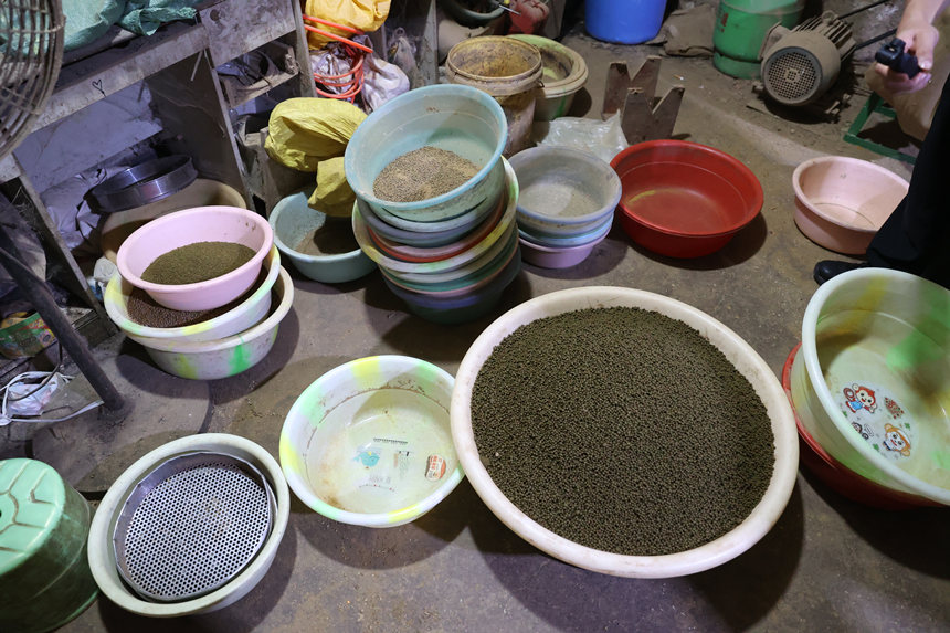 詐騙分子在簡易黑作坊里生產(chǎn)的“藥丸”。兩江新區(qū)警方供圖