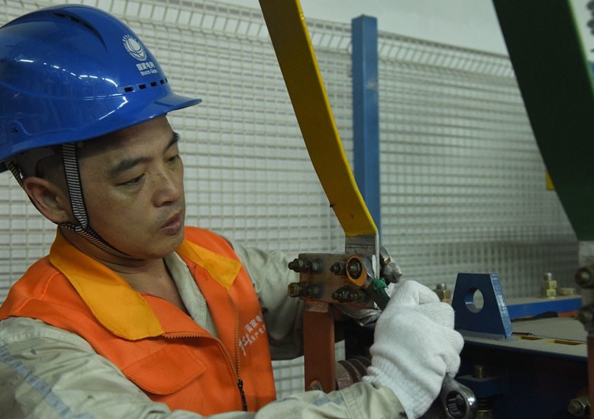 8月10日晚，國家電網(wǎng)紅巖（璧山運(yùn)檢）共產(chǎn)黨員服務(wù)隊隊員在110千伏大路變電站檢修4號電容器。周毅攝