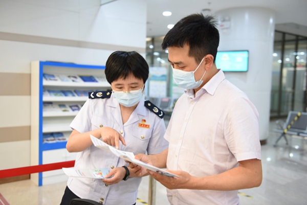 在辦稅服務(wù)廳，稅務(wù)人員向稅務(wù)特約監(jiān)督員介紹今年組合式減稅降費政策內(nèi)容。陳紅梅攝