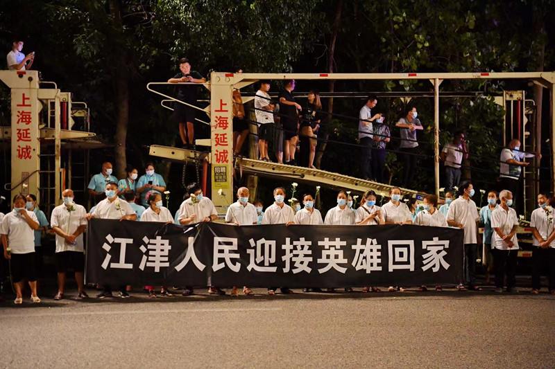 當(dāng)?shù)厝罕娮园l(fā)迎接英雄回家。賀奎攝