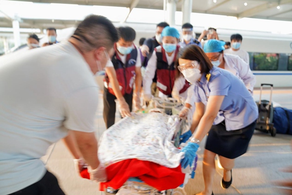 車站工作人員協(xié)助醫(yī)護(hù)人員轉(zhuǎn)運(yùn)燒傷患兒。汪亮攝