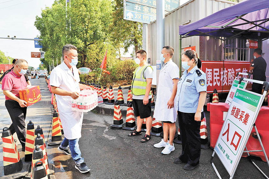 8月16日，成渝高速公路大足郵亭站核酸檢測點，郵亭鎮(zhèn)工作人員送來防暑降溫藥品、飲料等，保護核酸檢測點工作人員身心健康。通訊員 譚顯全 攝/視覺重慶