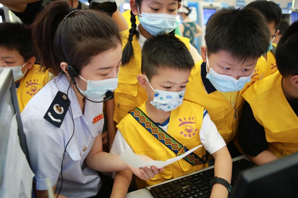 稅務(wù)人員教小朋友查驗發(fā)票真假。楊勝男攝