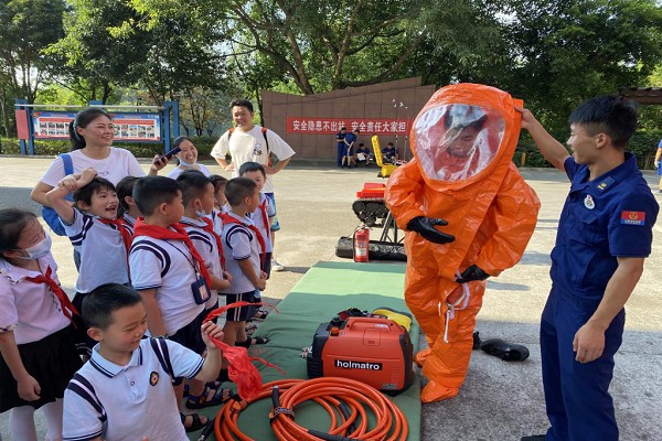 消防員向師生演示消防服的穿戴方法。渝北區(qū)消防救援支隊(duì)供圖