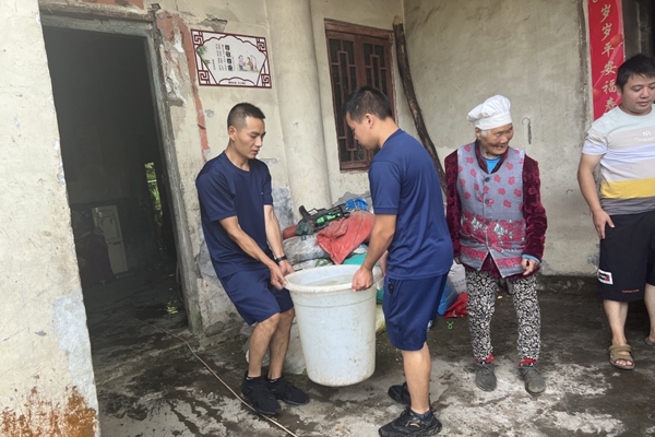 石柱縣消防員幫腿腳不便的老人抬水。石柱縣消防救援大隊供圖