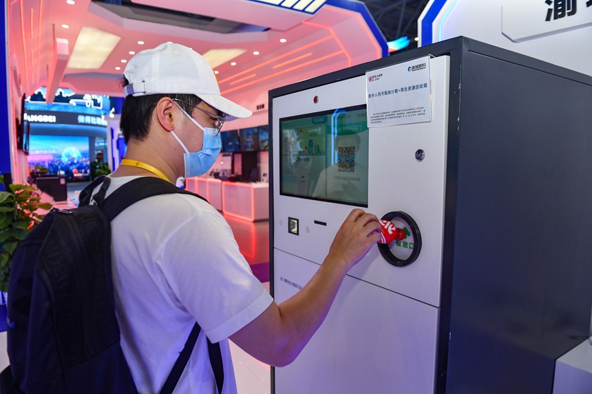 2022智博會重慶渝中區(qū)展廳，數(shù)字人民幣+再生資源回收項目展示，把喝完的水瓶投入回收箱，即可返還數(shù)字人民幣。鄒樂攝