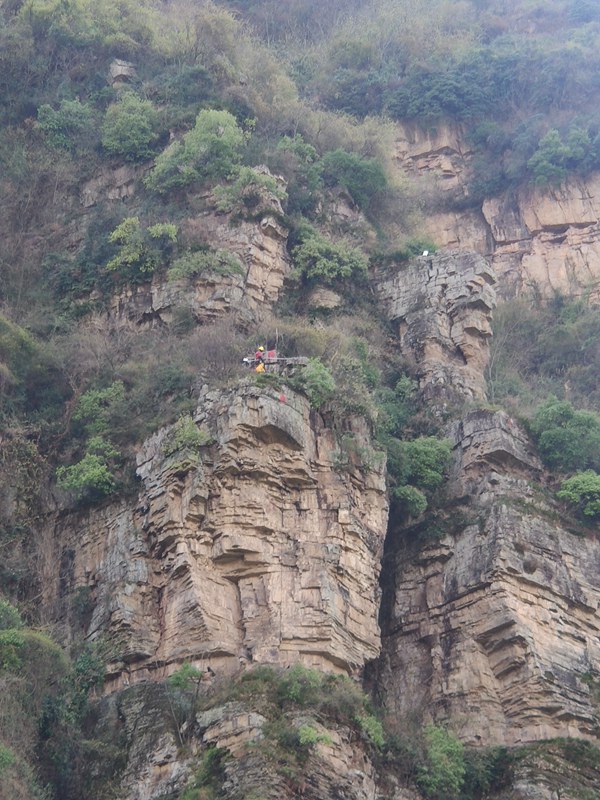 《三峽庫區(qū)巫山縣巫峽段專業(yè)監(jiān)測點儀器安裝》。3月17日，巫山縣長江右岸跳石村，“蜘蛛人”在懸崖絕壁安裝監(jiān)測儀器。吳月旭攝