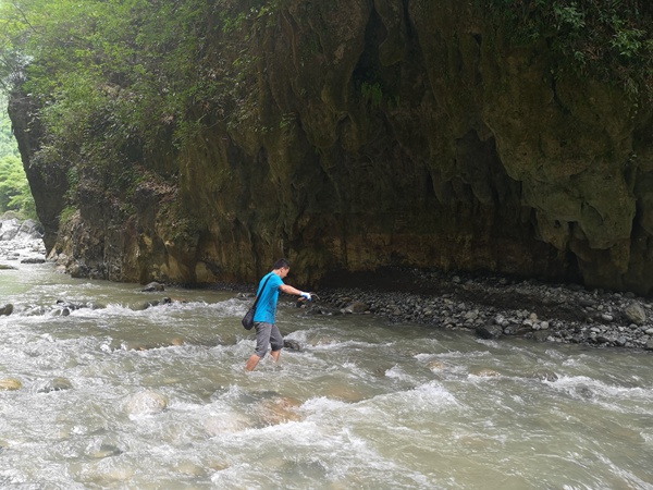 《過河》。6月30日，在巫山縣竹賢鄉(xiāng)下莊村谷底峽谷，川東南地質(zhì)大隊地災駐守隊員龔強蹚水過河到對面的地質(zhì)災害點進行調(diào)查。易洪志攝