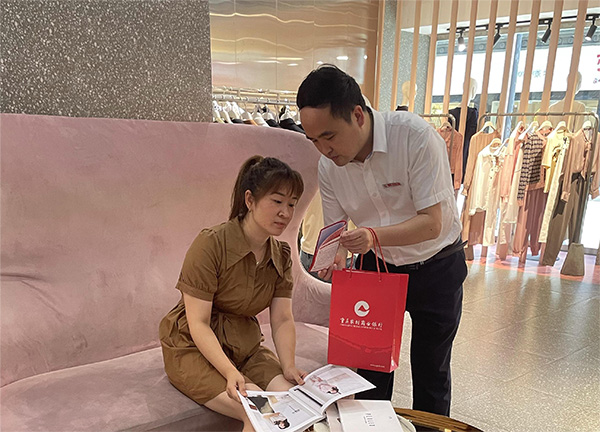 重慶農(nóng)商行武隆支行客戶經(jīng)理向周女士介紹創(chuàng)業(yè)擔(dān)保貸款相關(guān)政策。重慶農(nóng)商行供圖