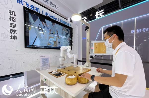 2022智博會科大訊飛展臺的工作人員演示與弈棋機器人對弈。人民網(wǎng) 胡虹攝