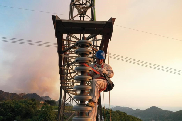 電力工人登塔開展搶修作業(yè)。李濤攝