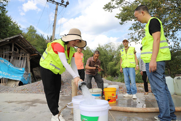 秀山縣應(yīng)急管理局黨員先鋒突擊隊(duì)隊(duì)員正在為村民接水。任燕攝