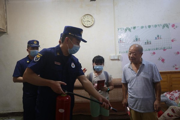 消防宣傳員為居民示范滅火器的使用方法。渝中區(qū)消防救援支隊(duì)供圖