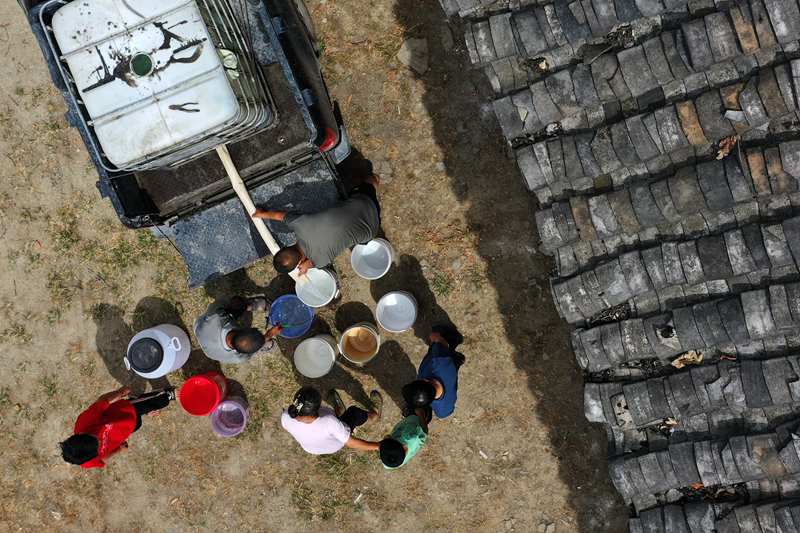 村民在送水車前接水。楊敏攝