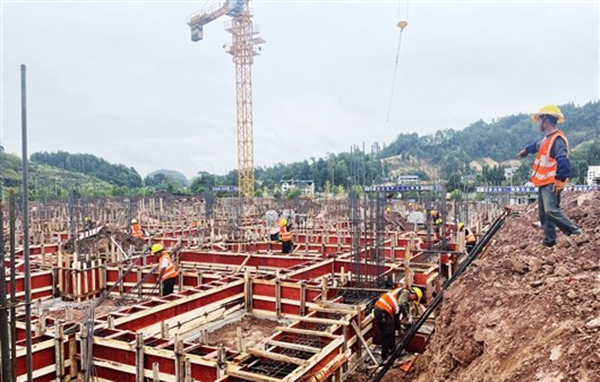 九隆現(xiàn)代中藥有限公司施工現(xiàn)場(chǎng)一派忙碌，工人在綁扎鋼筋、制作安裝模板。李佳遙攝