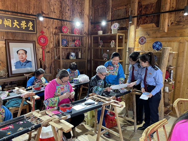 酉陽(yáng)縣稅務(wù)局工作人員走進(jìn)酉陽(yáng)縣子月苗族文化傳播有限責(zé)任公司，向苗繡職工講解組合式稅費(fèi)支持政策。 邱冰攝