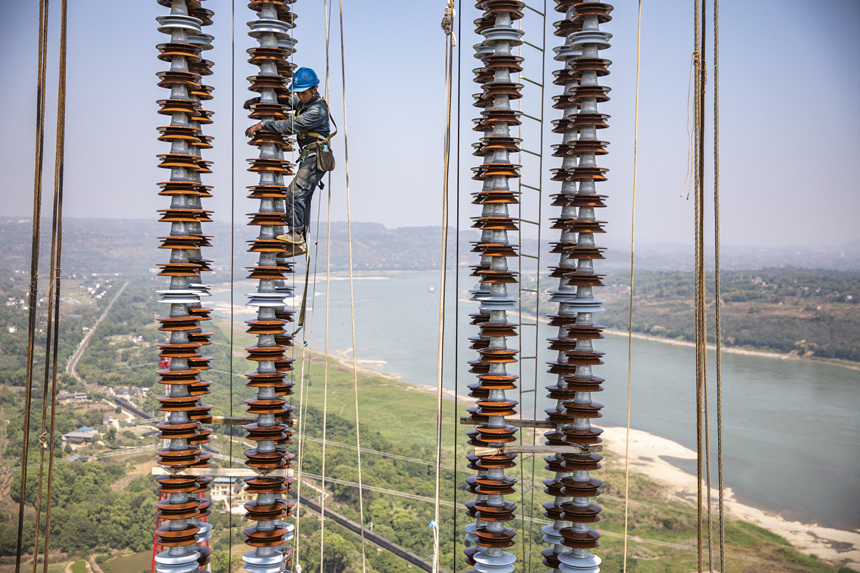 9月13日，在重慶市江津區(qū)白浙線長(zhǎng)江大跨越施工現(xiàn)場(chǎng)，施工人員正在攀爬絕緣子串。黃偉攝