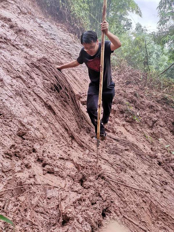 《踏破泥濘》。2020年8月3日，南江地質(zhì)隊駐守地質(zhì)隊員戴巖柯前往開州區(qū)白鶴街道牛馬騰滑坡為滑坡自動化監(jiān)測儀器安裝選址。途中遭遇道路塌方前行受阻，戴巖柯一手抓雜草一手撐木杖，踏著泥濘前往目的地。吳叔剛攝