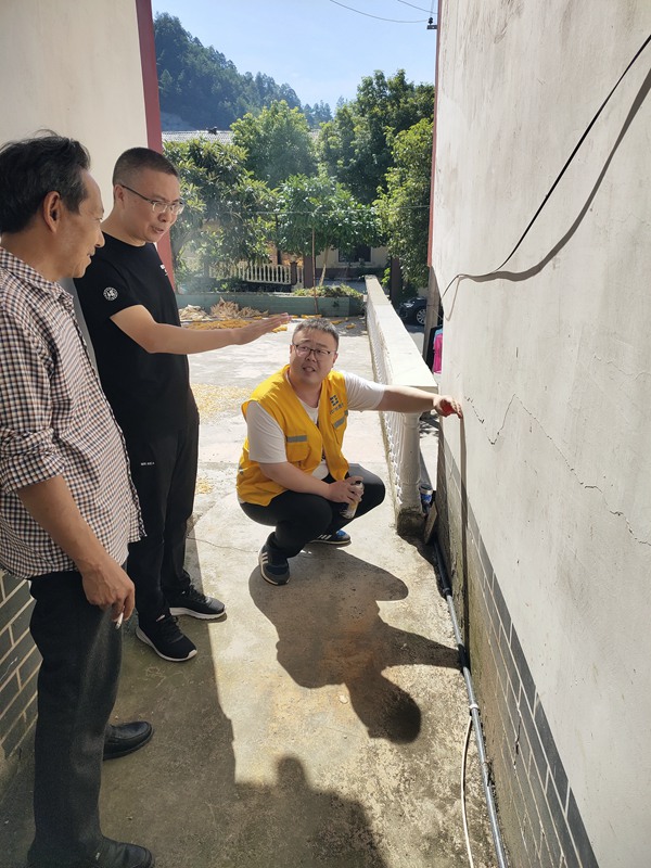 《炎炎夏日，地災(zāi)巡查力度不減》。8月9日，107地質(zhì)隊(duì)駐守隊(duì)員與沙壩鎮(zhèn)群測(cè)群防員頭頂烈日在萬(wàn)慶村地質(zhì)災(zāi)害隱患點(diǎn)開(kāi)展日常巡查，現(xiàn)場(chǎng)分析墻體裂縫形成的原因。路正昆攝