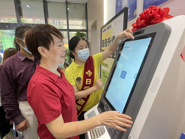 物業(yè)工作人員引導業(yè)主操作“鳳梨一號”。萬科物業(yè)供圖