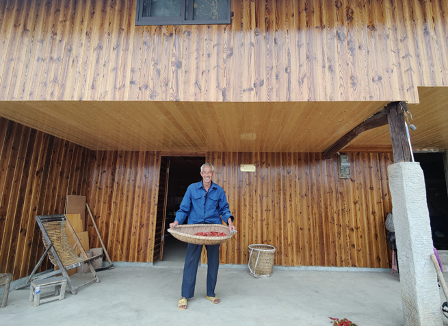 老黨員正在自家屋前篩小辣椒。徐俊聰攝