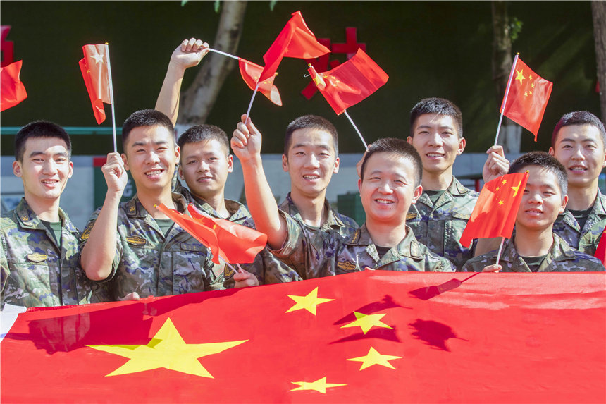 武警官兵揮舞國(guó)旗，祝福祖國(guó)繁榮昌盛。李東攝