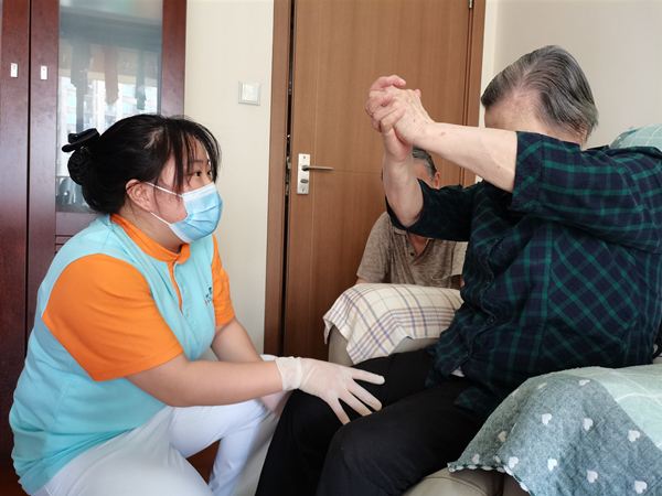 龍山街道社區(qū)養(yǎng)老服務(wù)中心護(hù)士長(zhǎng)指導(dǎo)長(zhǎng)者肢體康復(fù)訓(xùn)練。龍山街道供圖