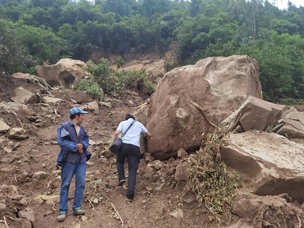 《應急調查黃柏鄉(xiāng)黃嶺樹危巖》。2021年5月25日，南江地質隊駐守隊員程俊（右）攜帶無人機對黃柏鄉(xiāng)黃嶺樹危巖進行應急調查，右側的孤石（直徑約3m）為調查前幾日危巖崩塌形成，距離下部房屋僅10m。劉偉攝