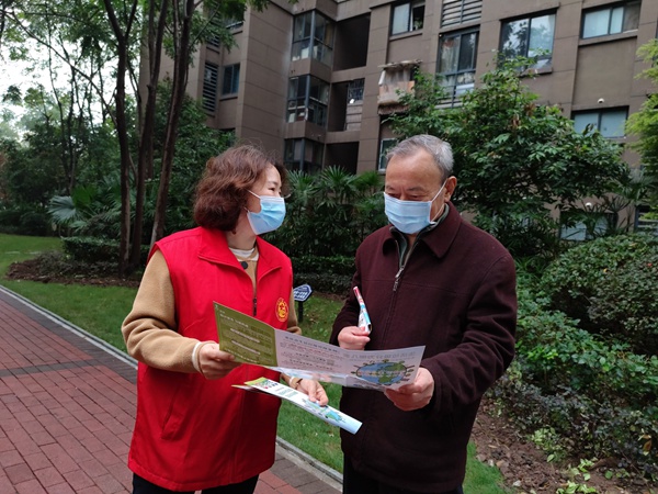 垃圾分類宣傳員給小區(qū)居民講解垃圾分類知識(shí)。