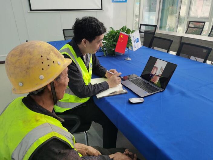 重慶軌道交通15號(hào)線項(xiàng)目幫助使用老年機(jī)的工友視頻聯(lián)系家人。發(fā)展公司供圖